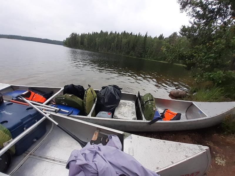 Due canoe piene di attrezzatura a riva di un lago al campo avventura in Svezia 
