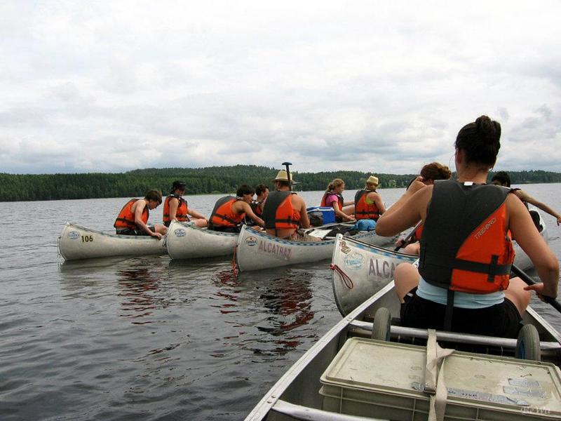 Gruppo di cinque canoe pronte per un attività di canottaggio al campo avventura in Svezia