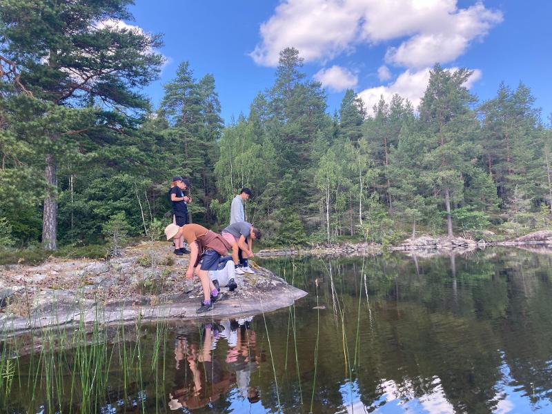 Ragazzi che giocano vicino all'acqua limpida al campo avventura in Svezia