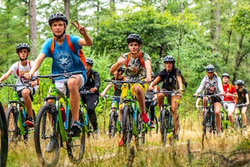 In questi viaggi studio per ragazzi, tanti ragazzi stanno facendo un'escursione in bicicletta nei boschi