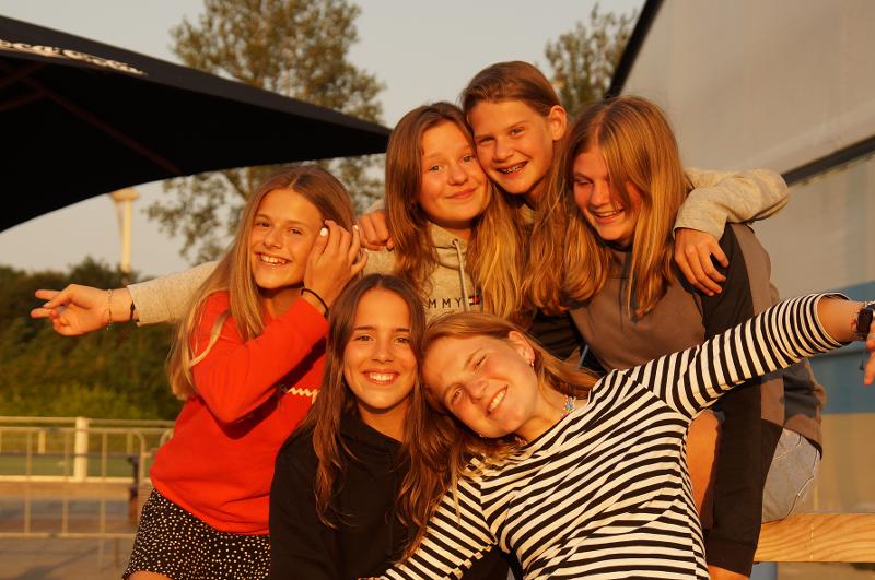 Alcune ragazze si abbracciano e sorridono al campo estivo internazionale di Hockey a Rotterdam