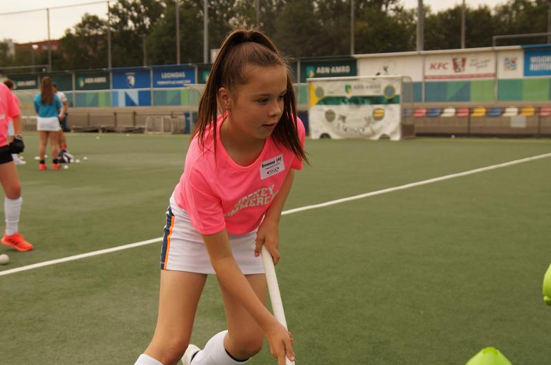 Al campo estivo internazionale di Hockey a Rotterdam una bambina concentrata si muove sul campo da hockey con la mazza