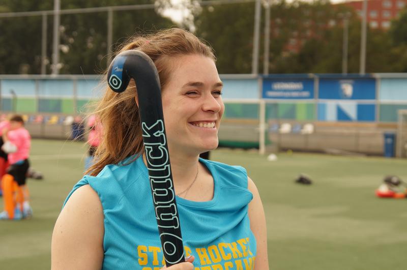 Al campo estivo internazionale di Hockey a Rotterdam una ragazza con la divisa azzurra sorride con la sua mazza da hockey