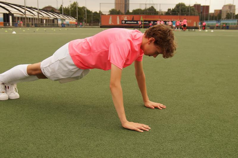 Al campo estivo internazionale di Hockey a Rotterdam un ragazzo fa delle flessioni sul prato