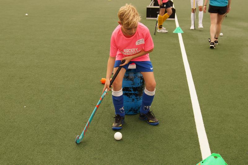 Un bambino esegue un esercizio di tecnica con mazza e palla al campo estivo internazionale di Hockey a Rotterdam