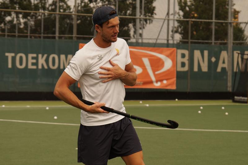 Al campo estivo internazionale di Hockey a Rotterdam, un maestro vestito di bianco tiene la mazza da hockey