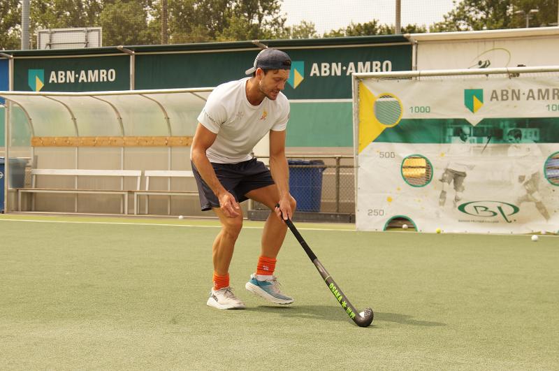 Un allenatore maneggia la mazza da hockey sul prato al campo estivo internazionale di Hockey a Rotterdam