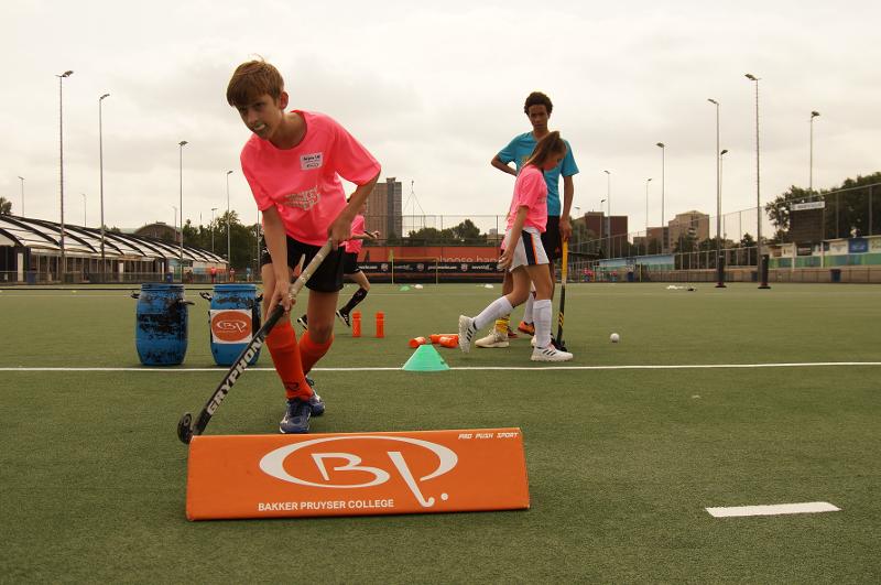 Un ragazzo con la protezione per i denti sta per eseguire un colpo di hockey con la mazza al estivo internazionale di Hockey a Rotterdam