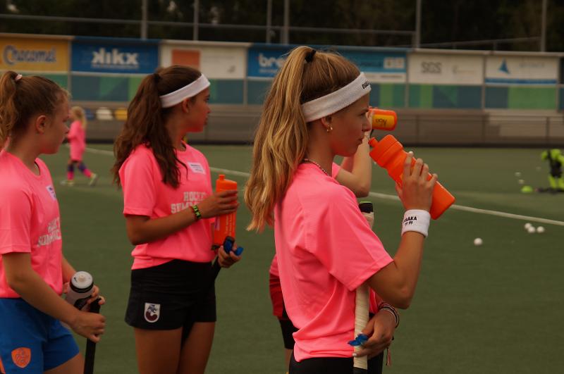 Al estivo internazionale di Hockey a Rotterdam alcune ragazze bevono dalle borracce nella pausa dalla partita al campo estivo internazionale