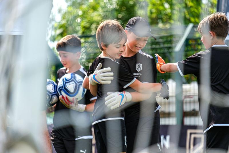 Due bambini del campus estivo calcio si abbracciano 