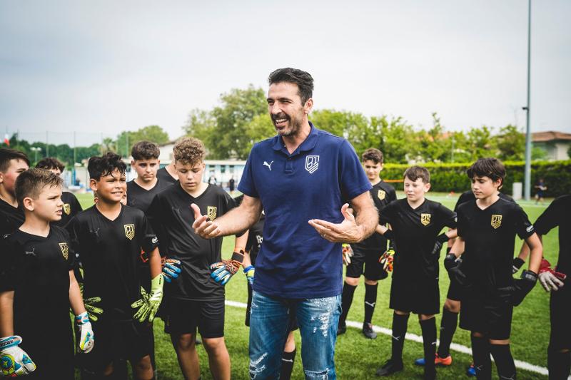 Il grande Gianluigi Buffon condivide la sua immensa esperienza con i giovani portieri del campus estivo calcio che lo circondano
