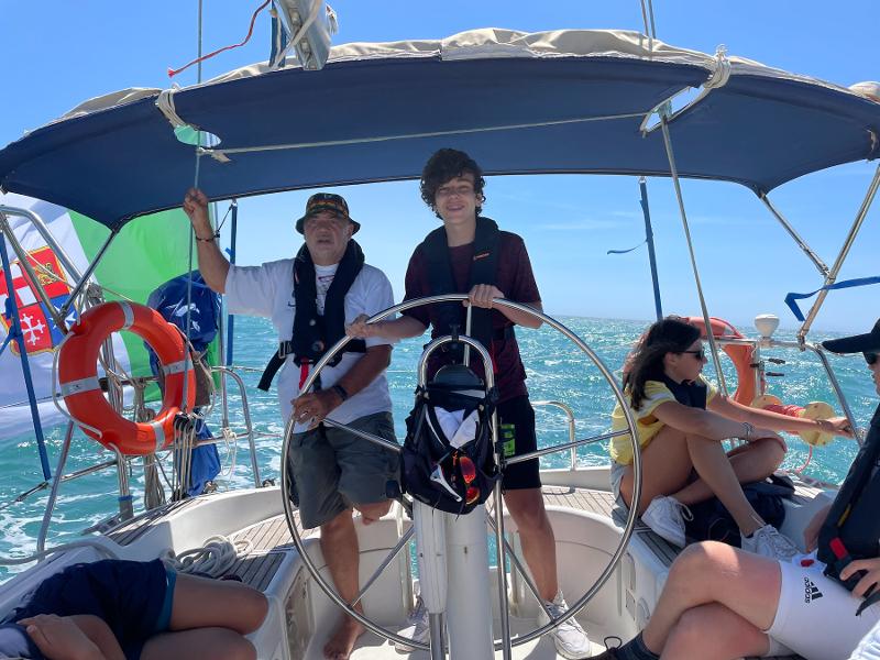 Al campo estivo vela un ragazzo prende il timone affiancato dall'istruttore