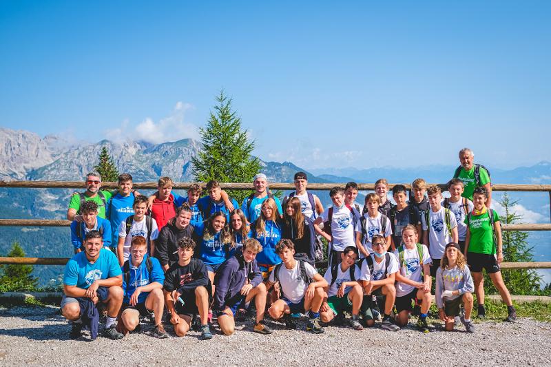 Tutti i ragazzi del gruppo fanno una foto insieme con sfondo montano ai campi estivi in Francia