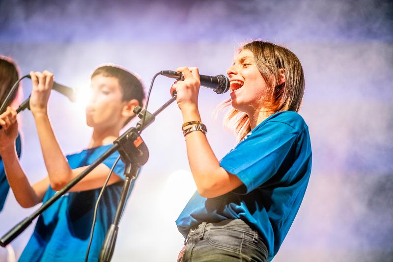 Al campo estivo musicale due ragazzi cantano appassionatamente al microfono
