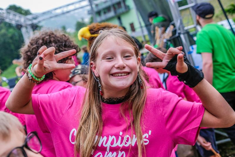Una giovane ragazza del campo estivo musicale sorride e posa
