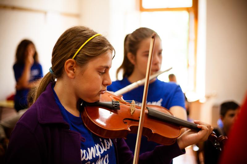 Una ragazza suona il violino e una il flauto al campo estivo musicale