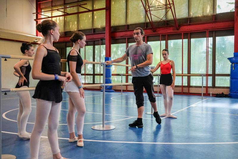 L'esperto istruttore del campo estivo danza dà indicazioni alle ballerine partecipanti