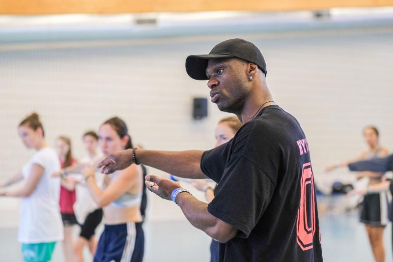 Un insegnante del campo estivo danza dà indicazioni agli allievi