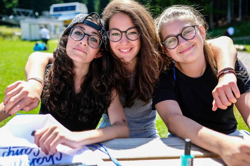 Tre amiche del campo estivo crescita personale scattano una foto insieme durante un'attività all'aperto