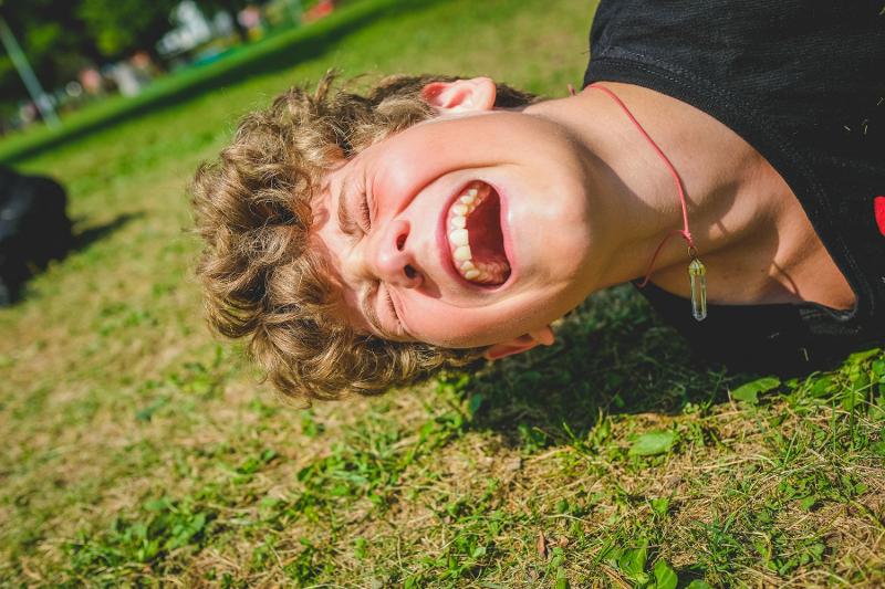 Un ragazzo partecipante al campo estivo crescita personale è steso per terra durante un gioco di gruppo
