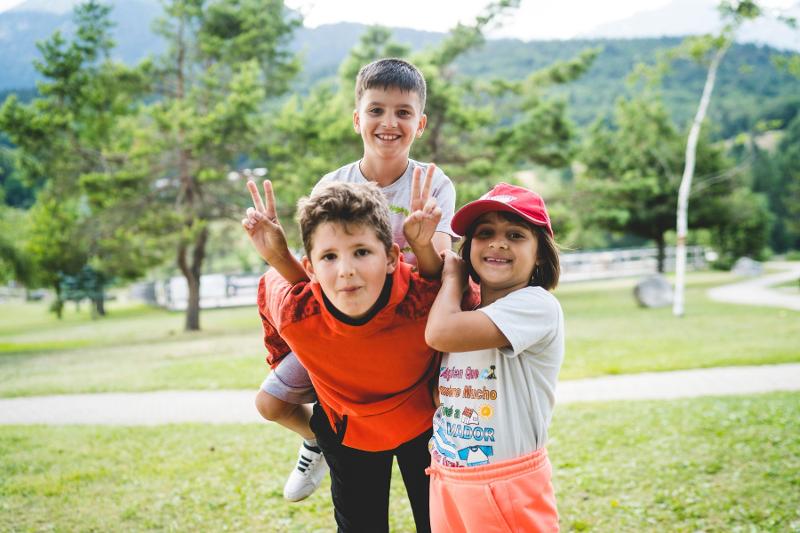 Tre partecipanti al campo estivo arte sorridono e scherzano