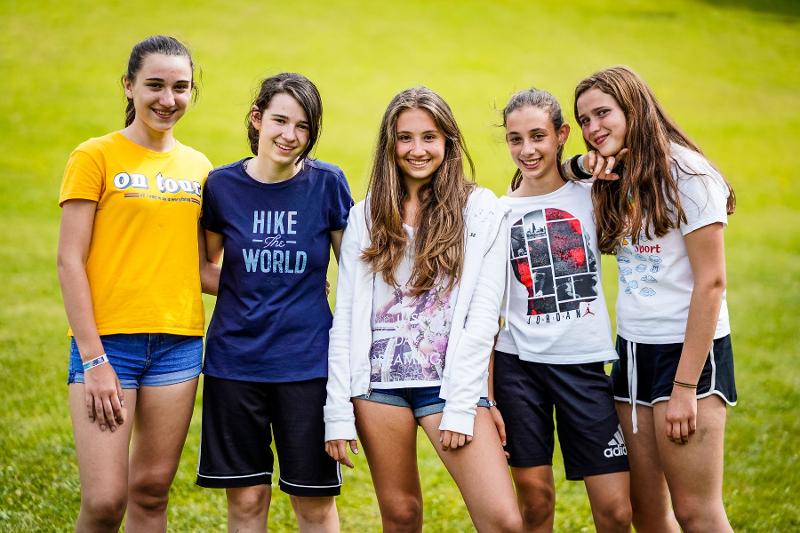 Un gruppo di cinque ragazze del campo estivo arte sorride per la foto di gruppo