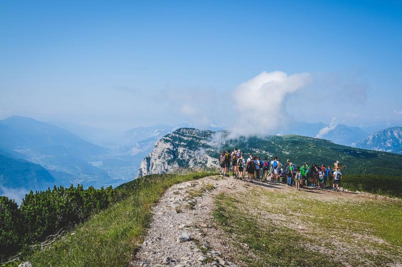 Il gruppo di partecipanti al campo estivo equitazione ammirano il panorama dalla vetta di una montagna 