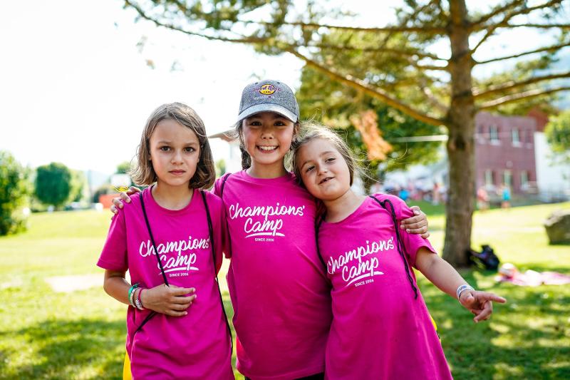 Tre bambine del campo estivo equitazione si abbracciano sorridendo