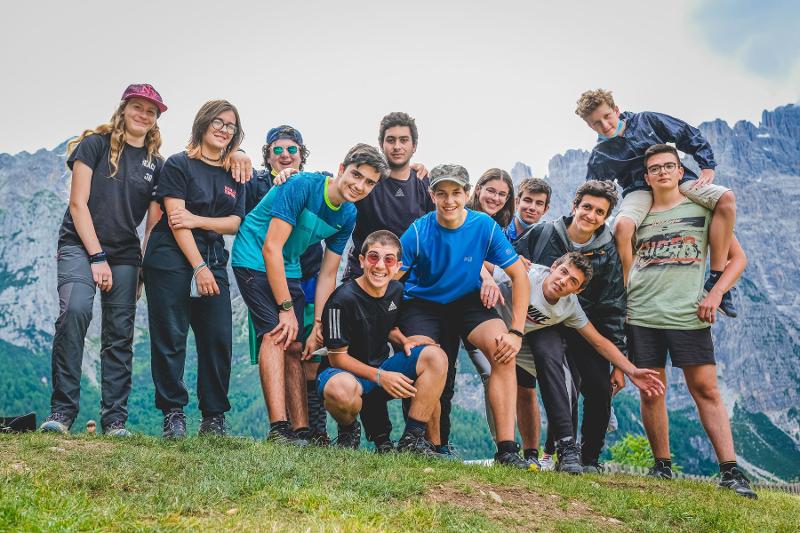 Un gruppo di partecipanti scatta una foto di gruppo in cima a una montagna al campo estivo tecniche di memoria