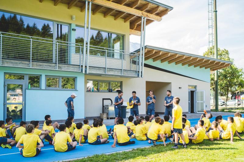 Gli allenatori del campo estivo calcio danno indicazioni ai giovani talenti