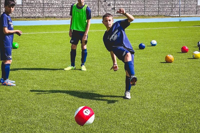 Un giocatore del campo estivo calcio ha appena eseguito un tiro a giro con l'esterno del piede