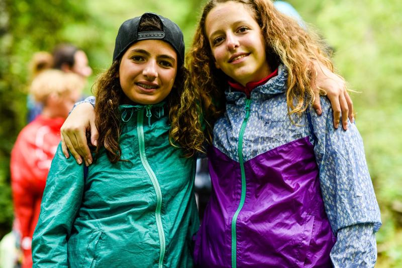 Due amiche del campo estivo inglese e sport sorridono e si abbracciano
