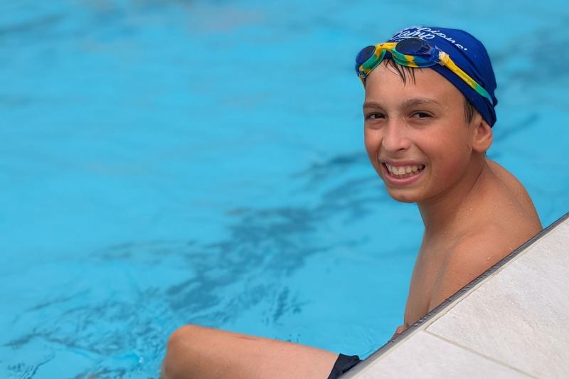 Un ragazzo del campo estivo inglese e sport è in piscina