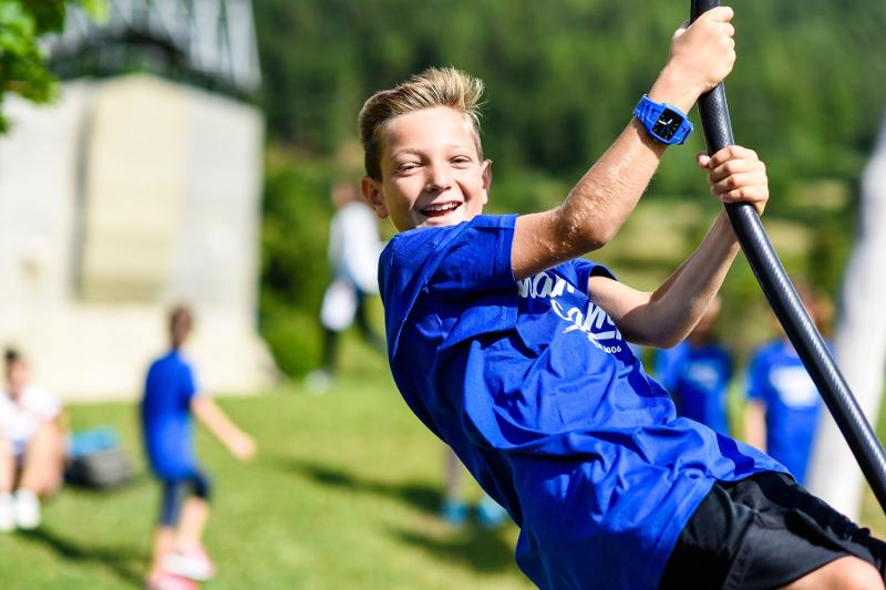 Un ragazzo si dondola sulla zipline al campo estivo inglese e sport