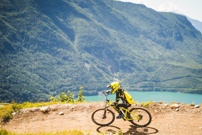 Un ragazzo sfreccia per i sentieri di montagna al campo estivo mountain bike