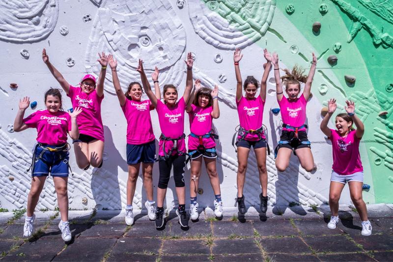 Un gruppo di ragazze del campo estivo multisport indossa vestiti rosa e posa per la foto