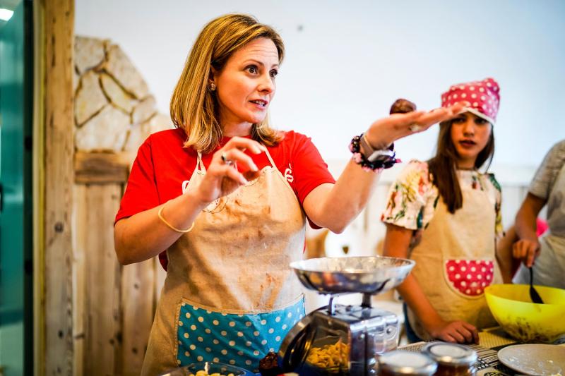 Un'insegnante del campo estivo cucina mostra agli allievi come eseguire la ricetta del giorno
