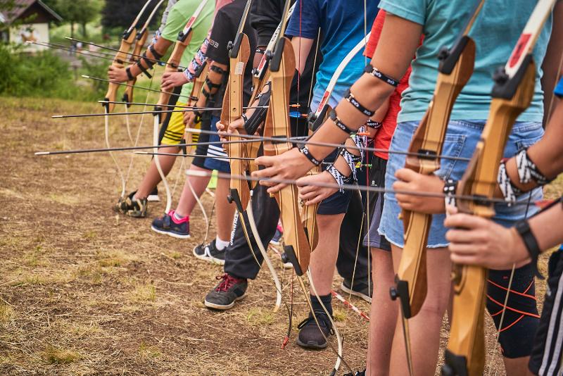 Al campo estivo di inglese in Italia, si vedono i ragazzi che provano a scoccare le frecce con gli archi
