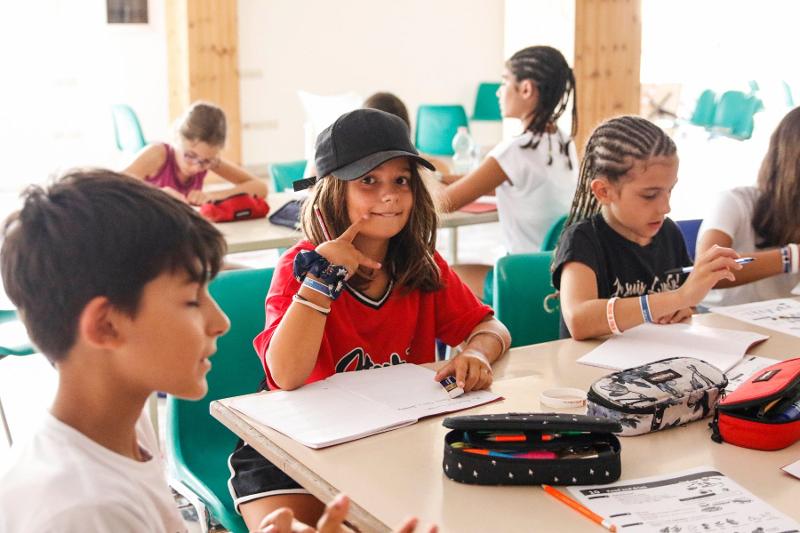 Ai centri estivi tre bambini partecipano ad una lezione di inglese