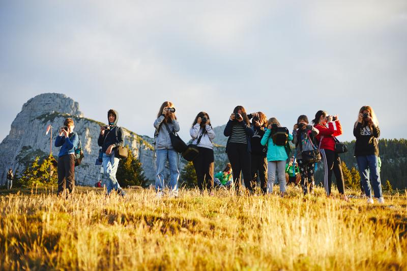 Ragazzi e ragazze stanno scattando una fotografia con le macchinette al campo estivo fotografia
