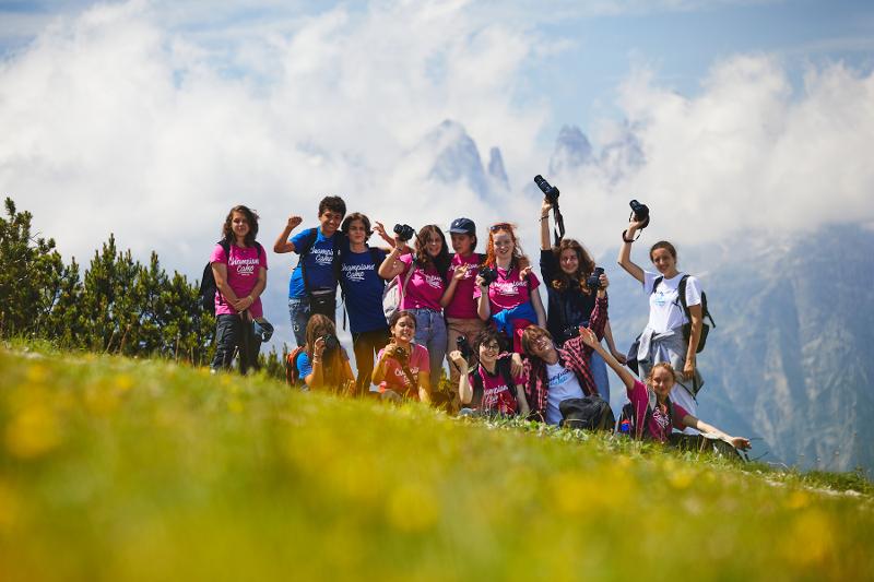 Al campo estivo Svizzera, i ragazzi fanno una foto circondati dalle montagne e dalle nuvole e si mettono in pose divertenti
