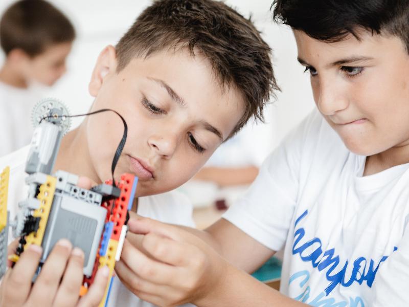 Al campo estivo Trentino Alto Adige di Lego due bambini osservano e costruiscono un oggetto insieme