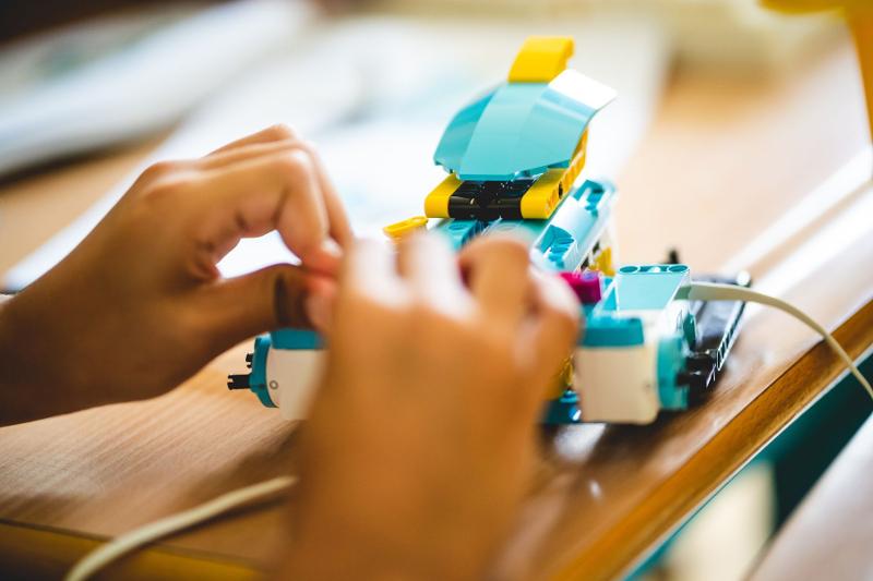 Un partecipante del campo estivo Trentino Alto Adige di Lego costruisce una macchina con mattoncini e cavi