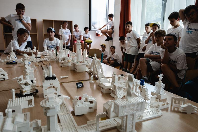 I bambini del campo estivo Trentino Alto Adige di Lego osservano insieme le costruzioni bianche sul tavolo
