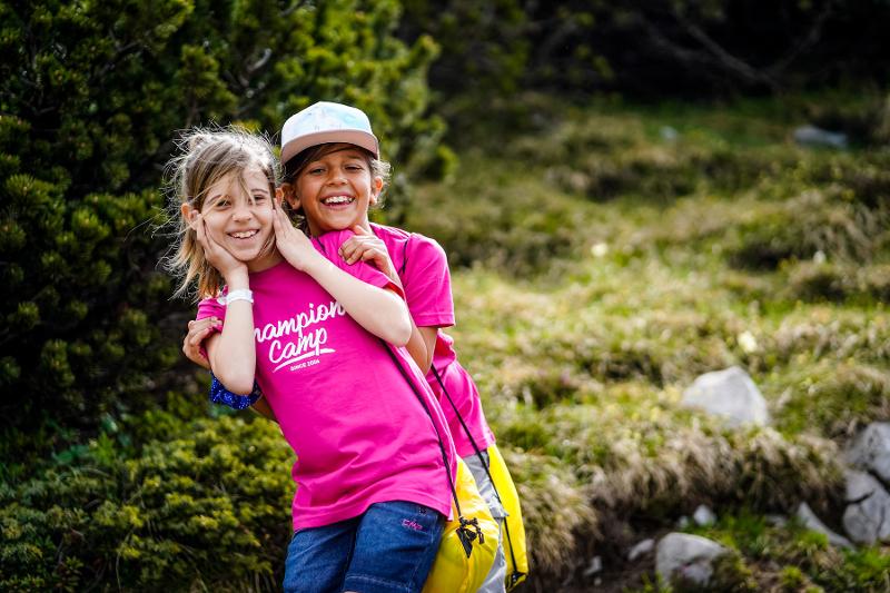 Al campo estivo multisport due ragazze in rosa ridono e stanno vicine