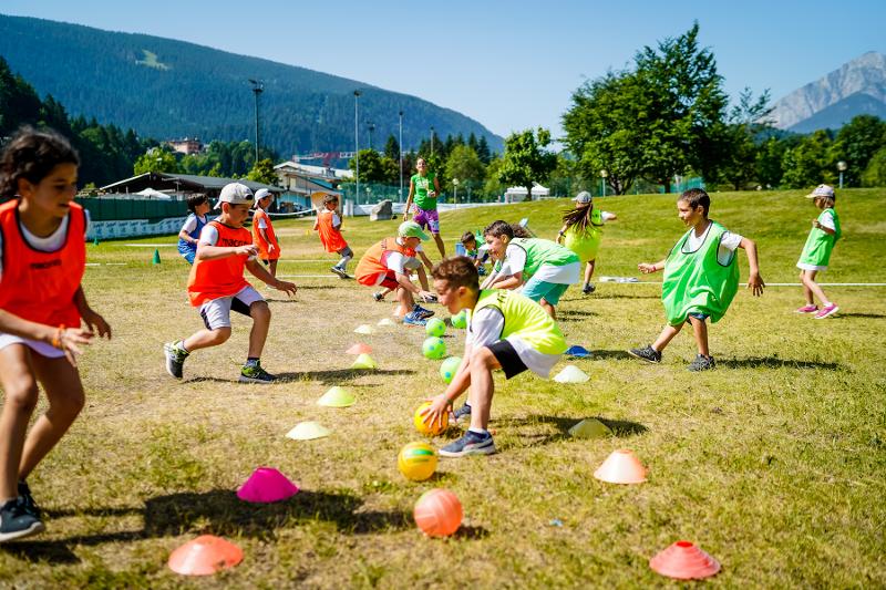 Al campo estivo multisport i ragazzi eseguono un gioco a squadre dove chi prende prima la palla vince