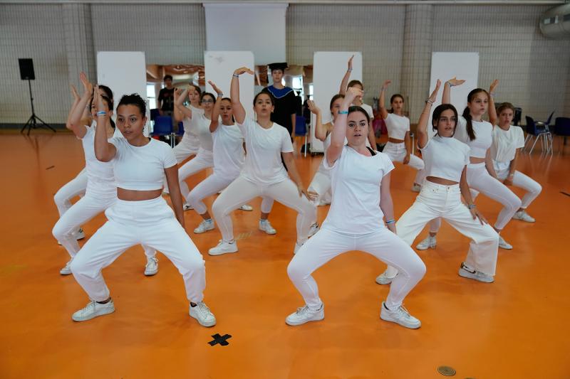 Alcune ragazze in bianco provano una coreografia di gruppo al campo estivo recitazione