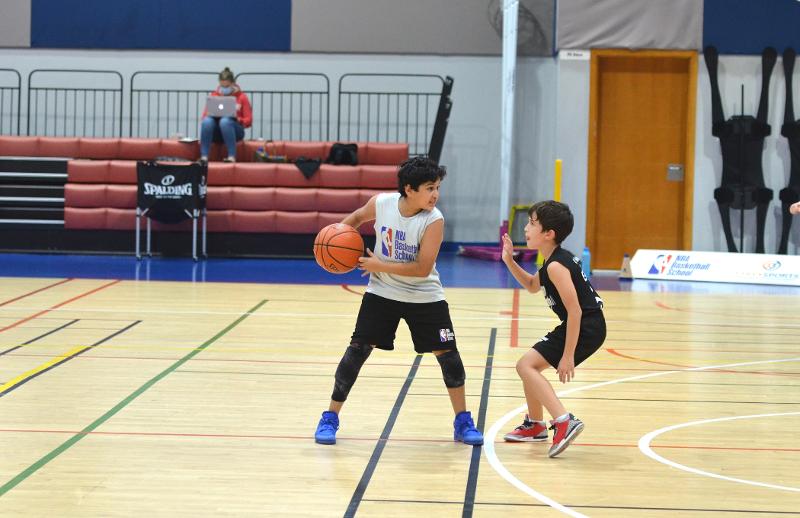 Durante il campo estivo basket due bambini giocano in due squadre opposte