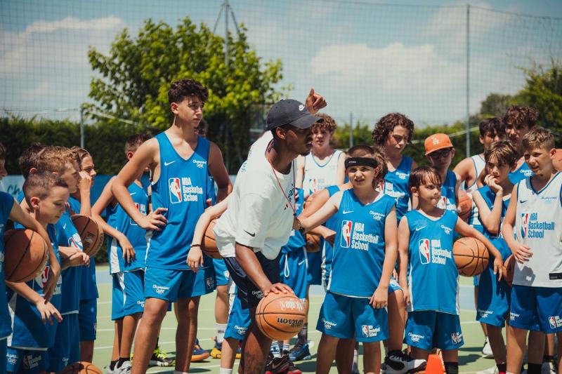 Il coach del campo estivo basket dà indicazioni ai suoi giocatori