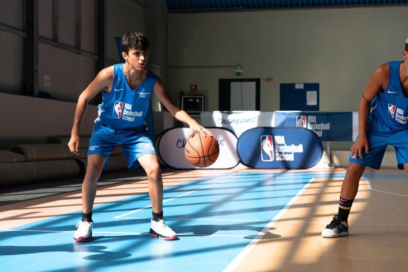 I ragazzi si allenano sul palleggio al campo estivo basket